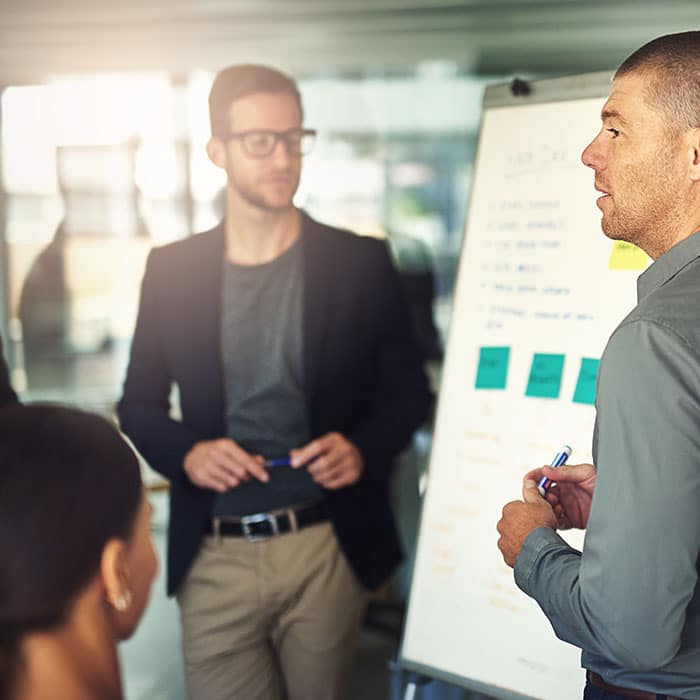 Two men making a presentation to a group at a startup company. 